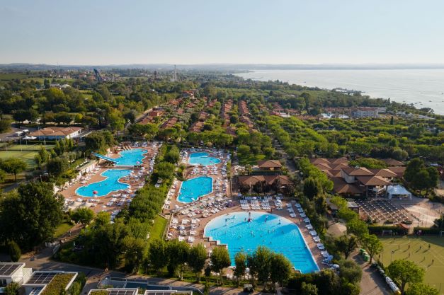 Aerial view of Piani di Clodia campsite with multiple swimming pools and green trees.